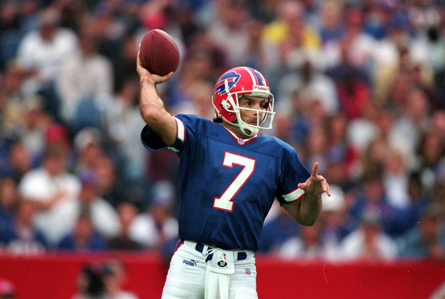 Buffalo Bills #7 quarterback in blue jersey throwing football before packed stadium crowd
